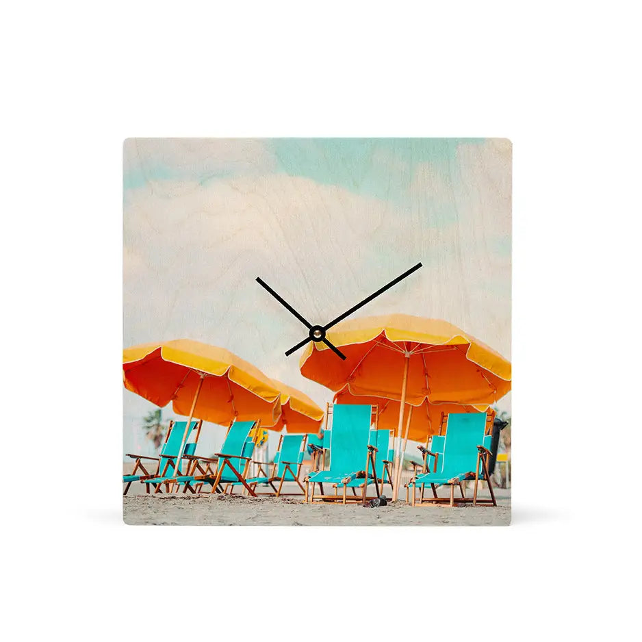 Wall clock with beach scene, orange umbrellas, and turquoise lounge chairs for personalized wood clocks.