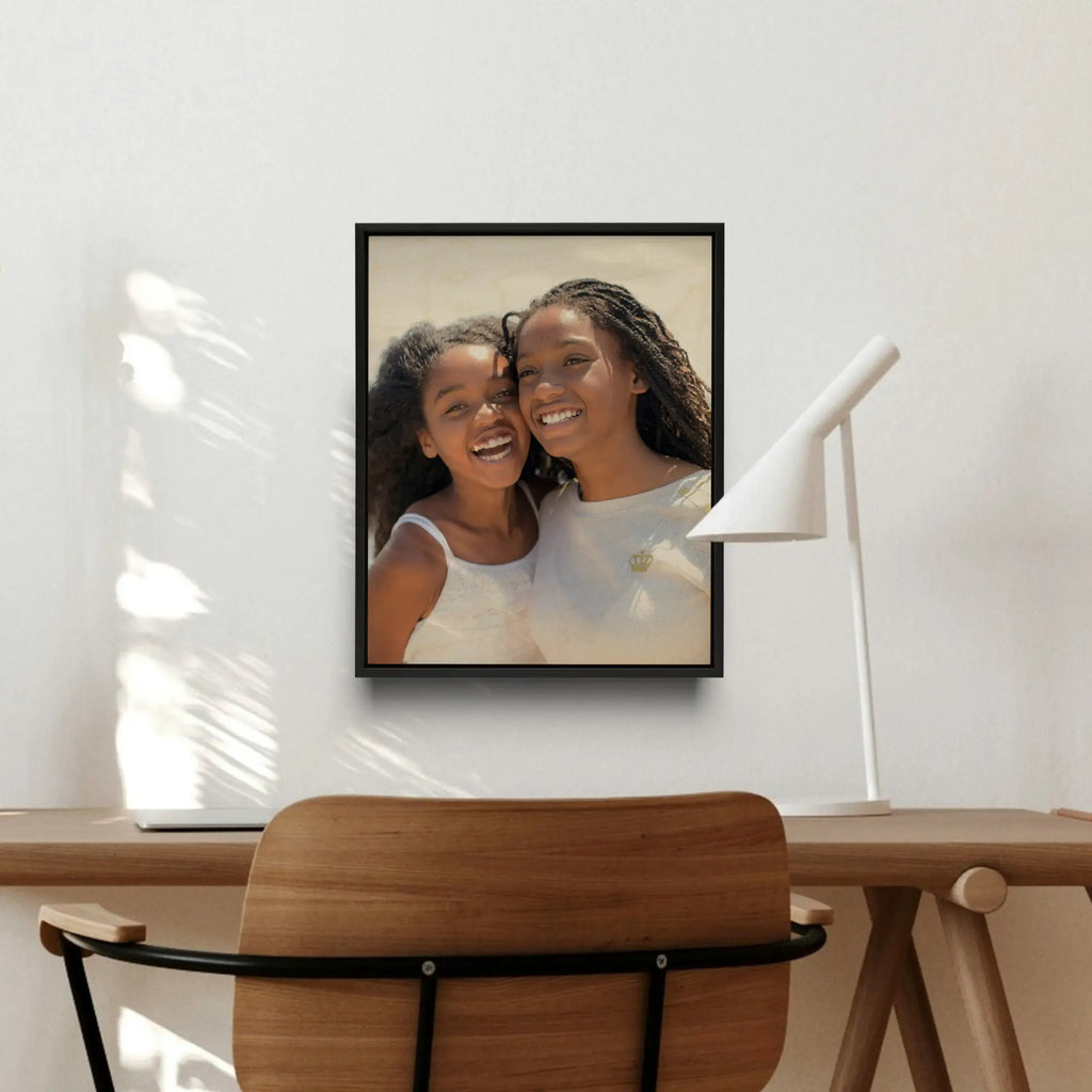 Framed wood print of two smiling women with dark hair embracing, showcasing photo printing.