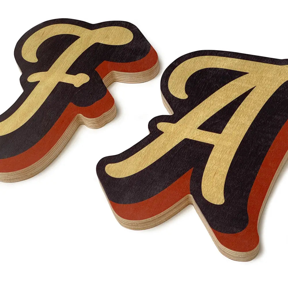 Three-dimensional letters ’F’ and ’A’ in gold, black, and red layered design.