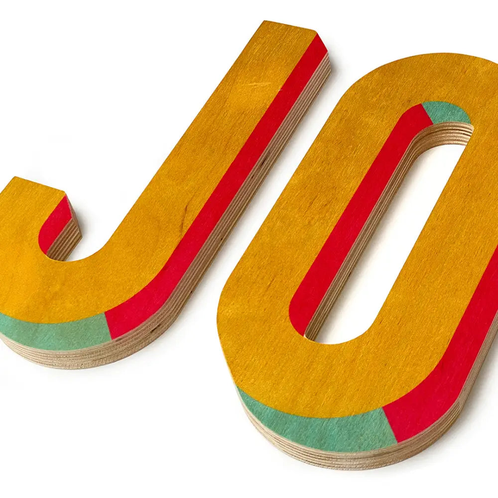 Colorful wooden letters ’JO’ with layered edges in yellow, red, and green.