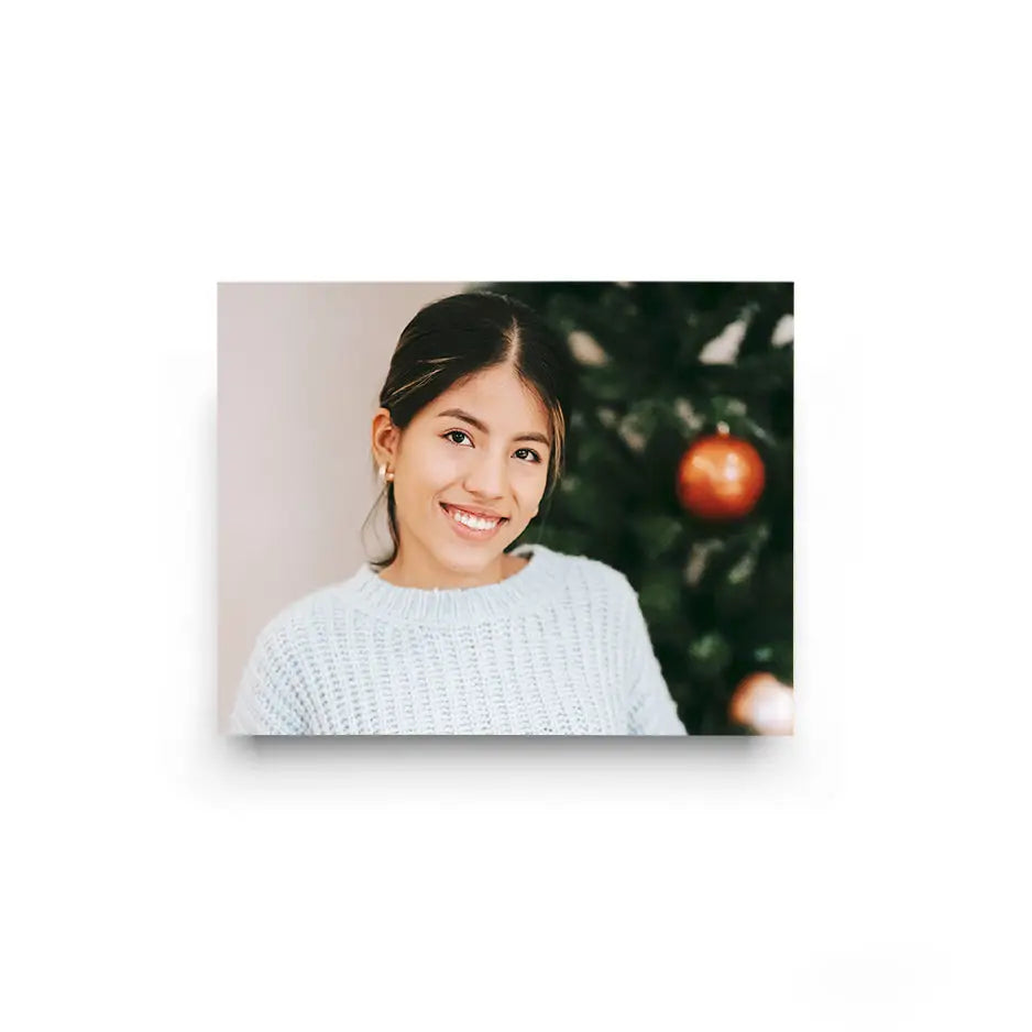 Smiling woman in a white sweater with a Christmas ornament by a 10x14 cove photo mount