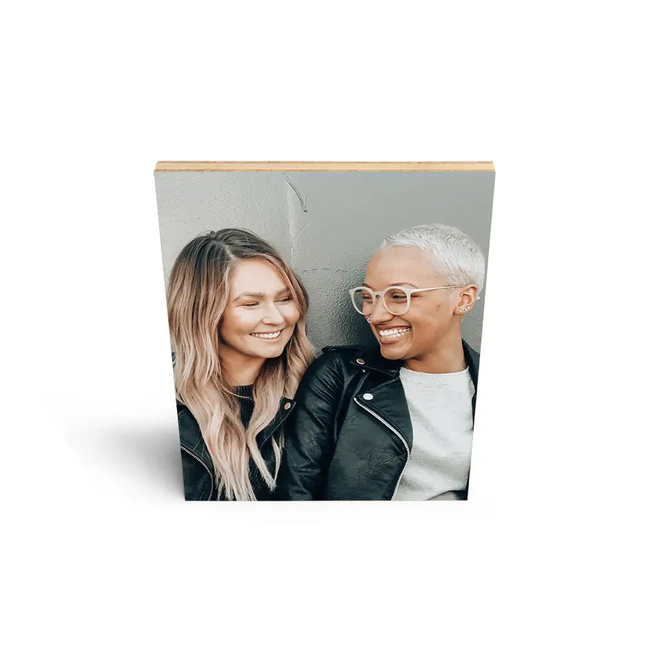 Two people on a white background showcasing an 11x14 bamboo wood print