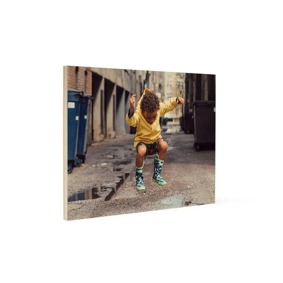 Boy in yellow shirt and green shoes jumping on street in 11x14 wood print