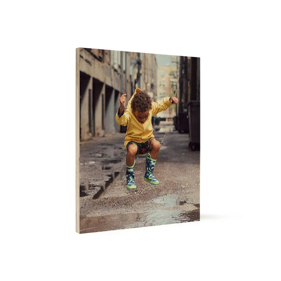 Child joyfully playing in the rain on an 11x14 wood print for a nostalgic touch