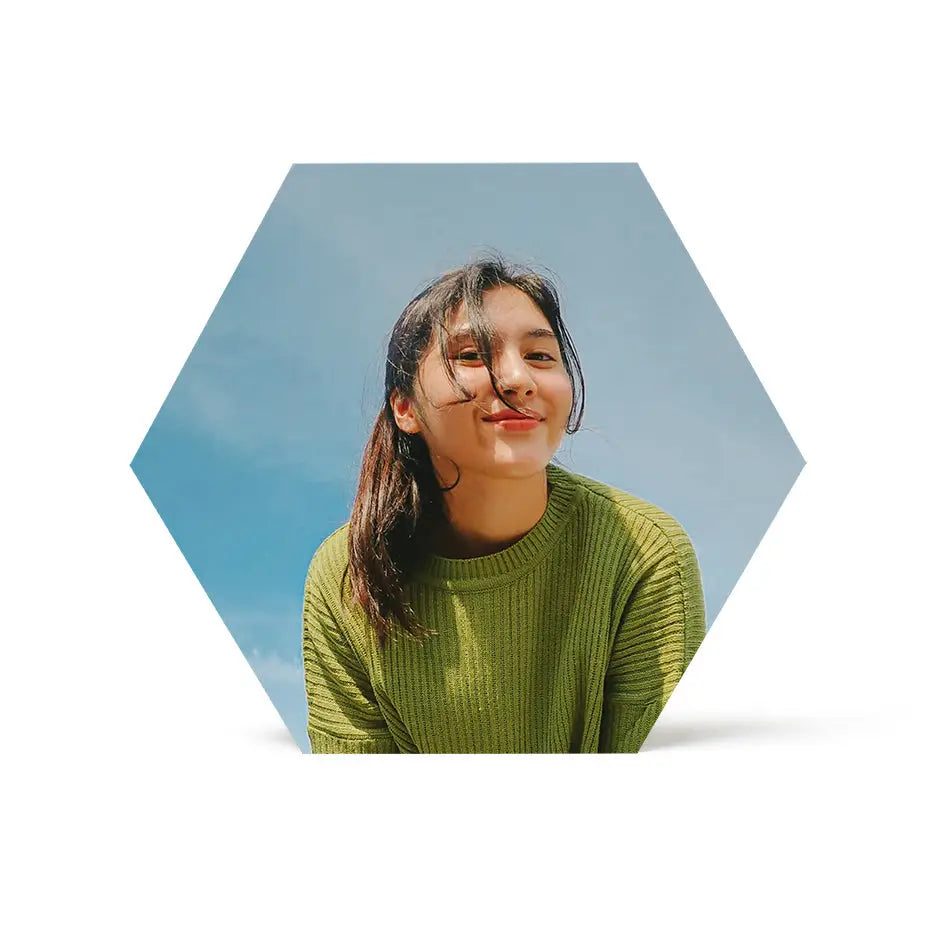 Woman in green sweater with long hair next to 12x12 hexagon wood print display