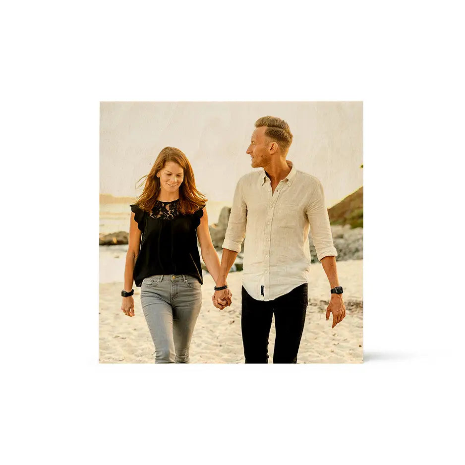 A man and woman walking on the beach in a 12x12 wood print vintage design