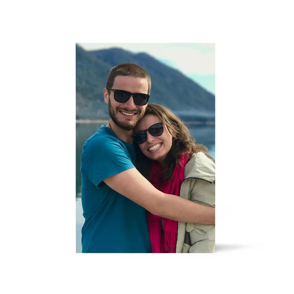 A man and woman hugging on the beach in a 12x18 wood print bright white