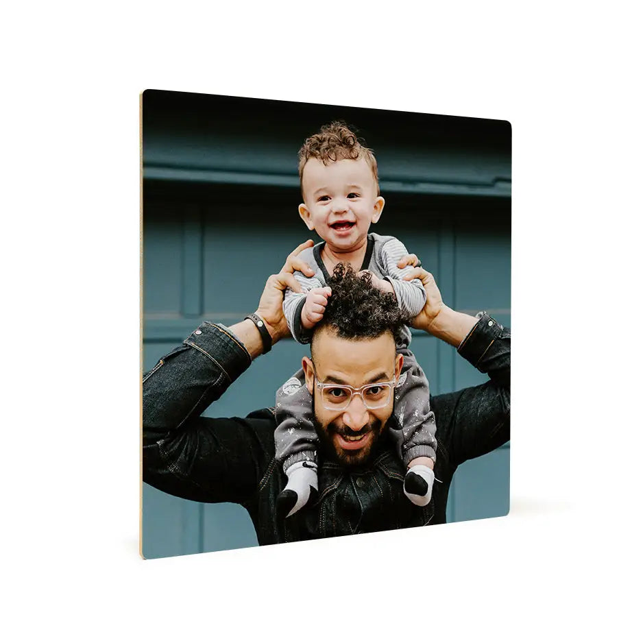 Man holding a baby in his arms displayed on a 16x16 photo tile