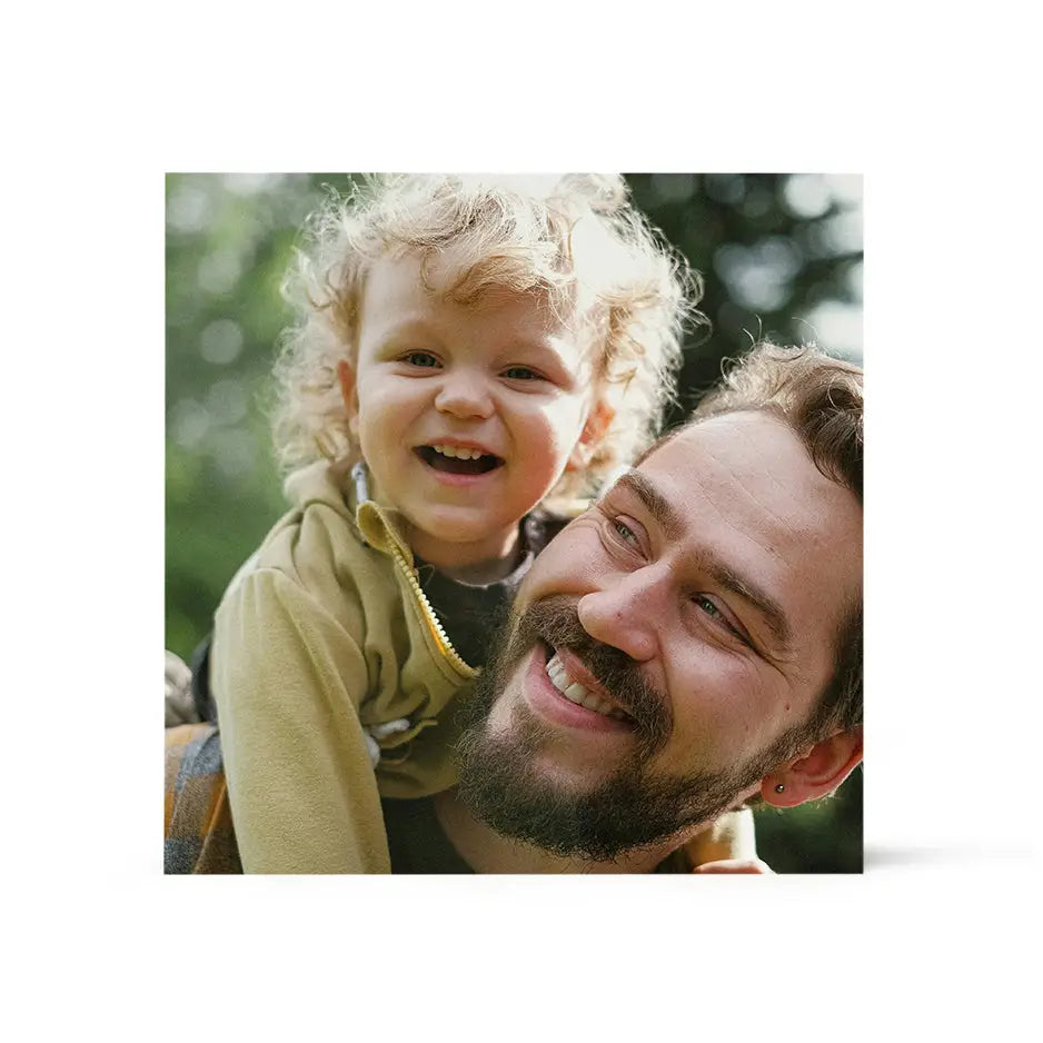 Man holding child in a 16x16 Wood Print Bright White, showcasing a heartwarming moment