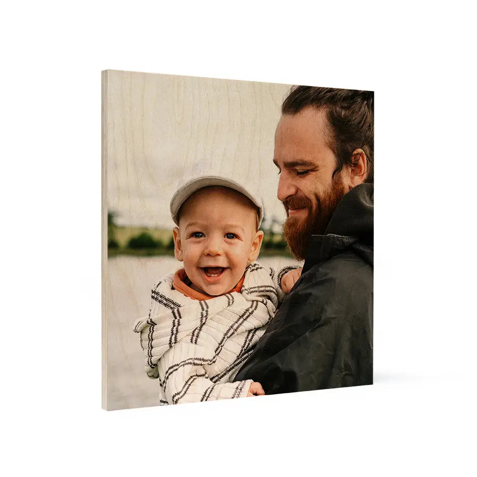 Man holding a baby in arms featured on a 16x16 wood print vintage decor piece