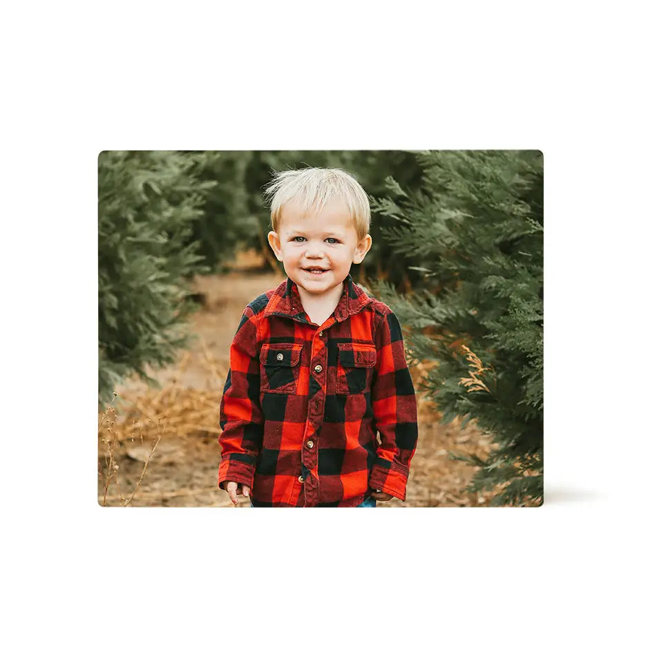 Boy in red and black plaid shirt by Christmas tree on a 16x20 photo tile