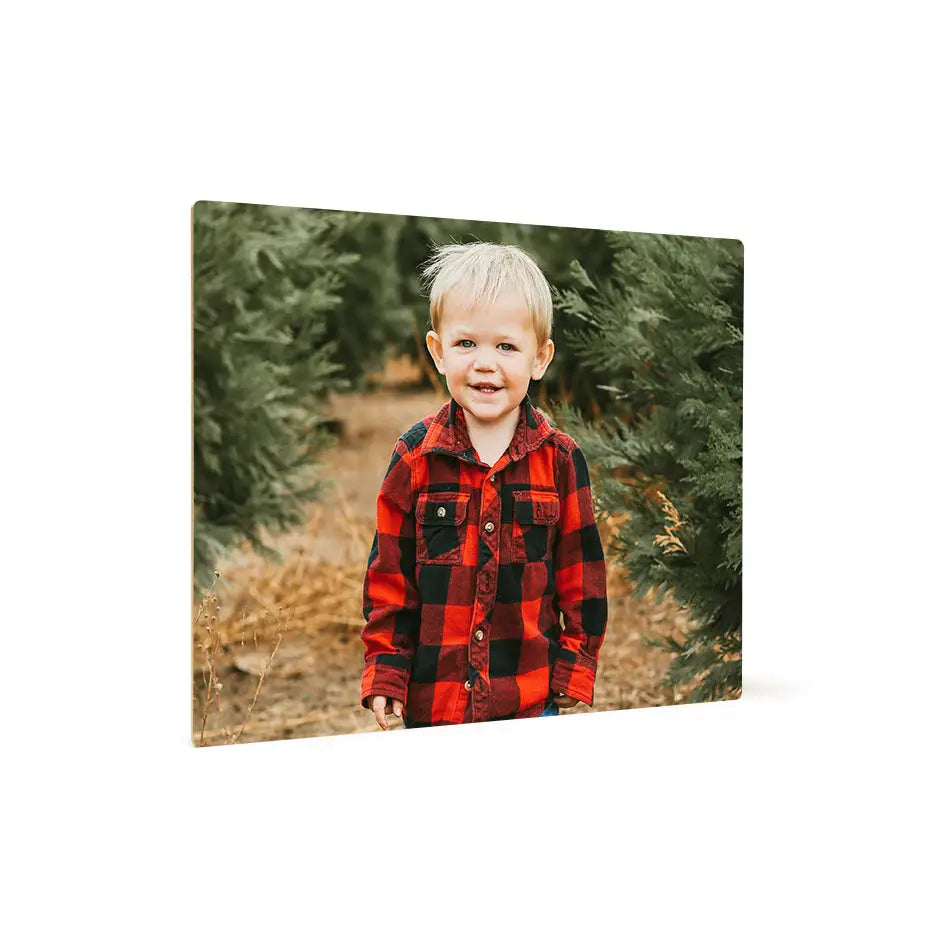 Boy in a red and black plaid shirt by a Christmas tree on a 16x20 photo tile