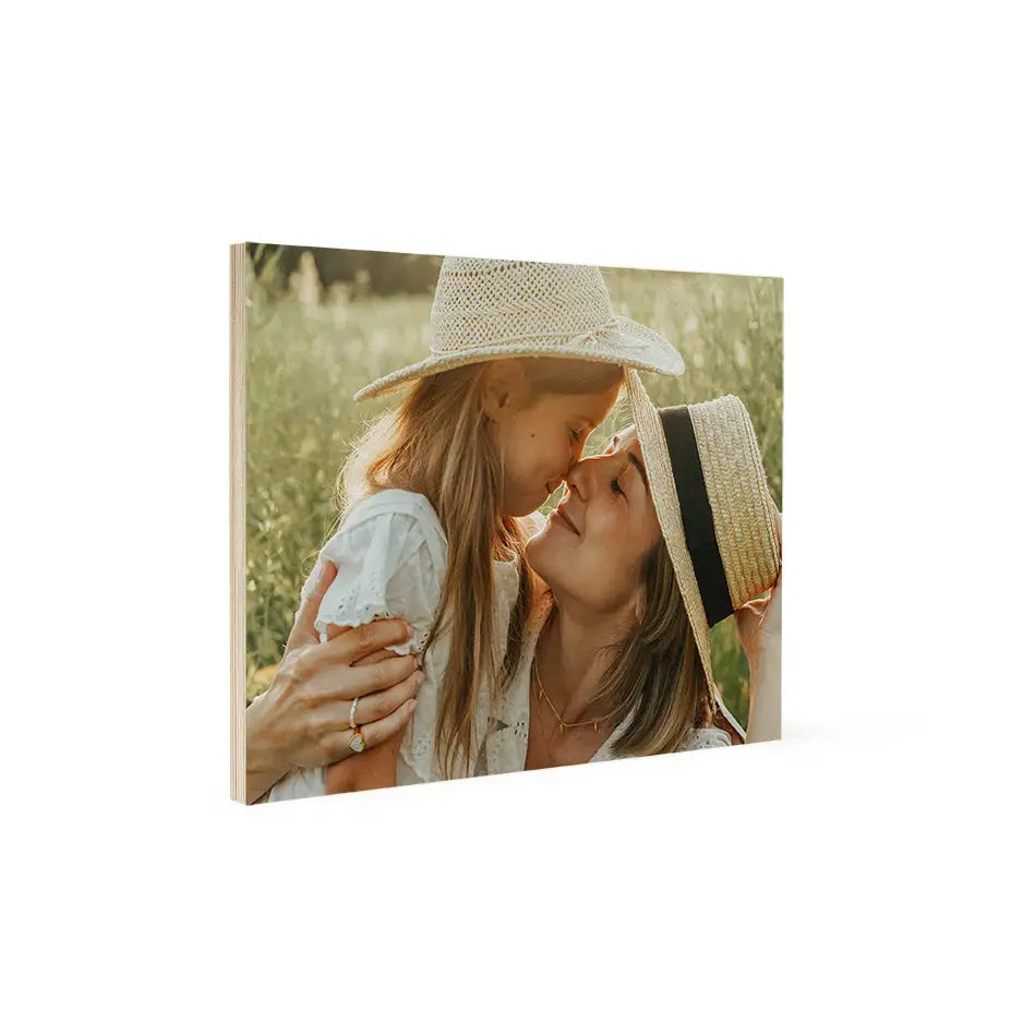 A woman kissing her daughter in a field on a 16x20 wood print bright white