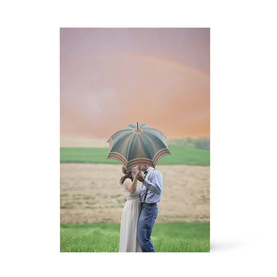 Couple kissing under an umbrella in a field on a 20x30 wood print display