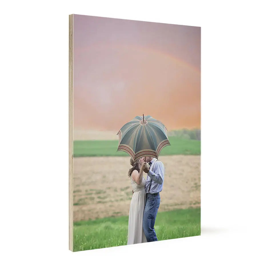 Couple kissing under an umbrella in a field on a 20x30 wood print