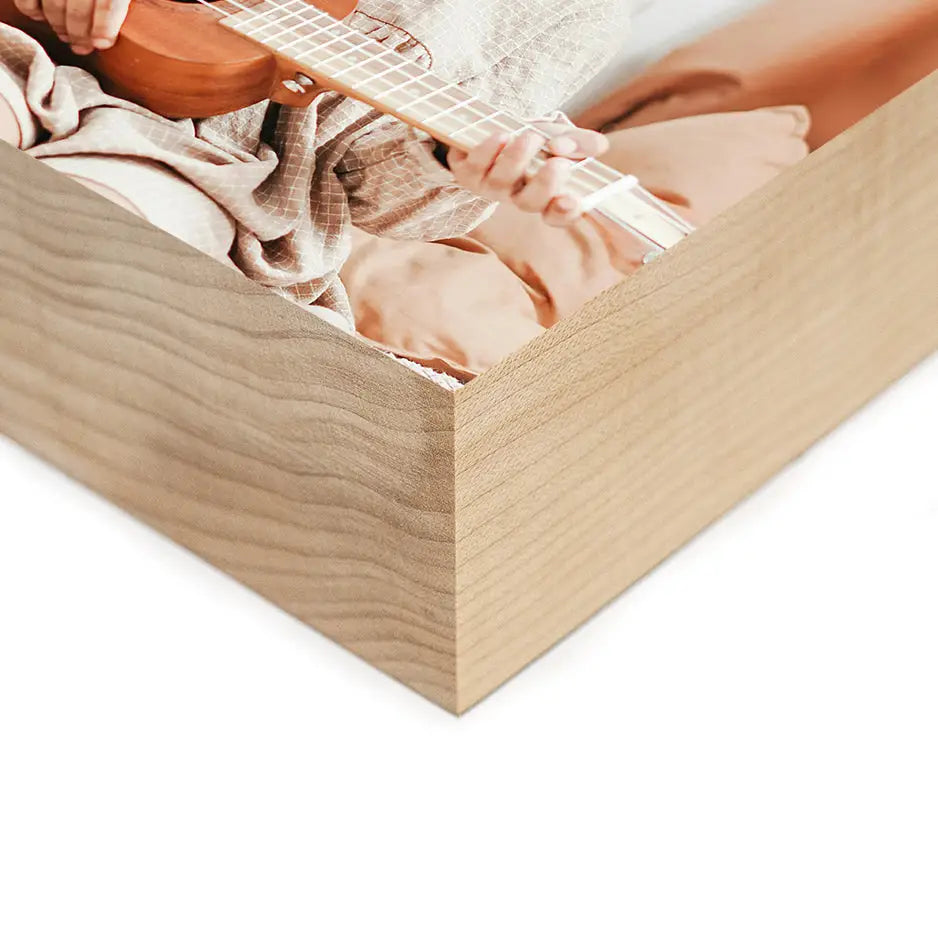 Person playing guitar in a wooden box with 3x3 Maple Photo Block design