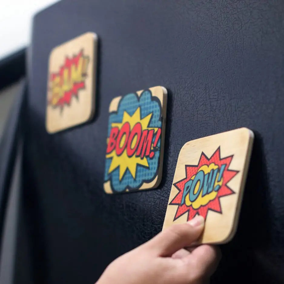 Person placing a button on a blackboard with a 4x4 Square Wood Print Magnet Set