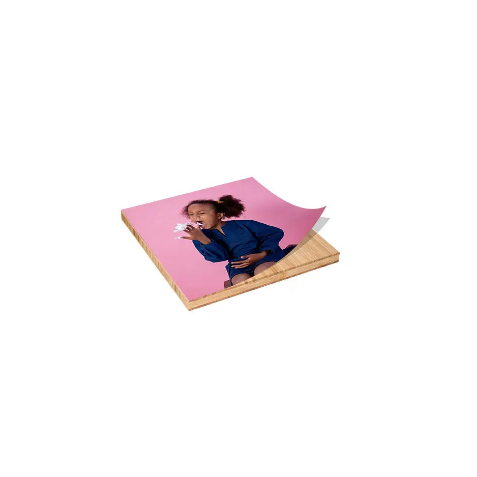 Woman in a blue dress sitting on pink surface, shown on 6x6 bamboo wood print