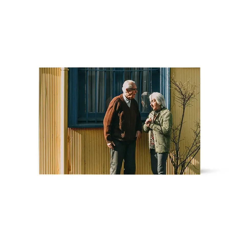 Man and woman in front of a yellow building on an 8x12 wood print bright white