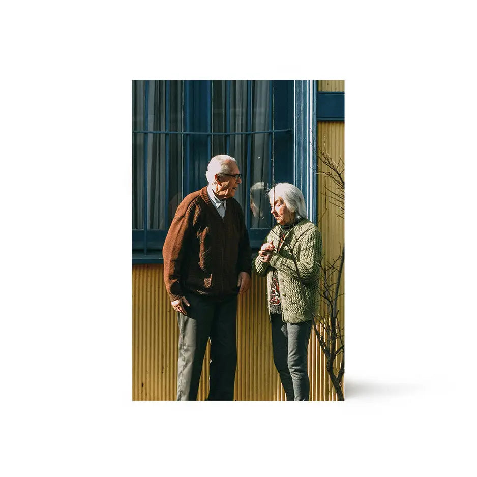 Older couple standing in front of a house on an 8x12 wood print bright white design