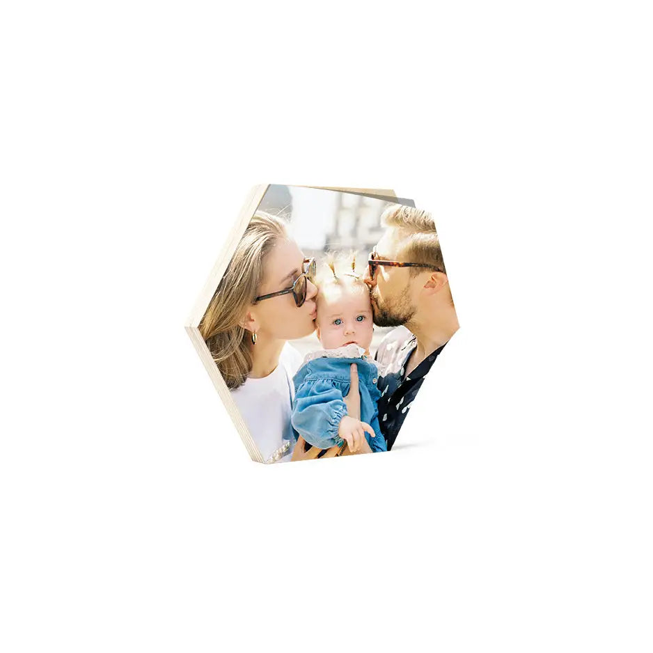 Couple kissing with baby in arms on a beautiful 8x8 hexagon birch photo mount