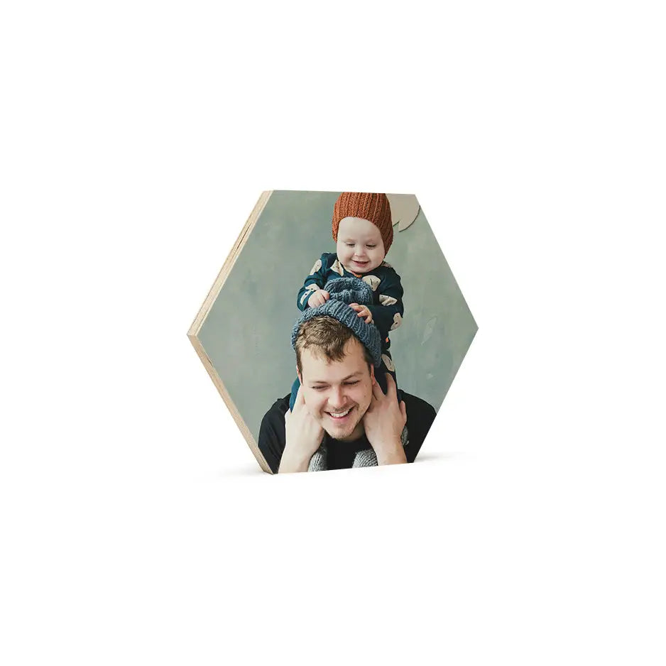 A man holding a child in his arms on an 8x8 hexagon wood print