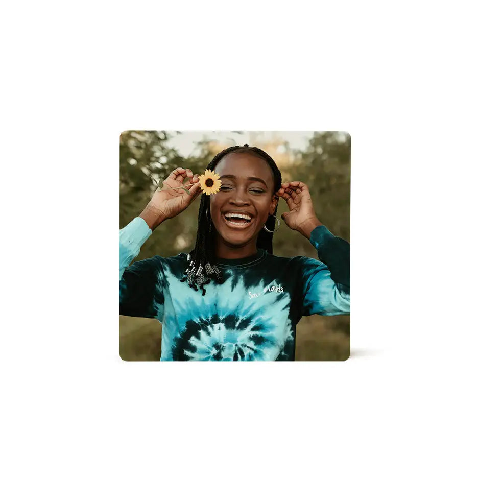 Smiling woman holding a flower on an 8x8 photo tile backdrop