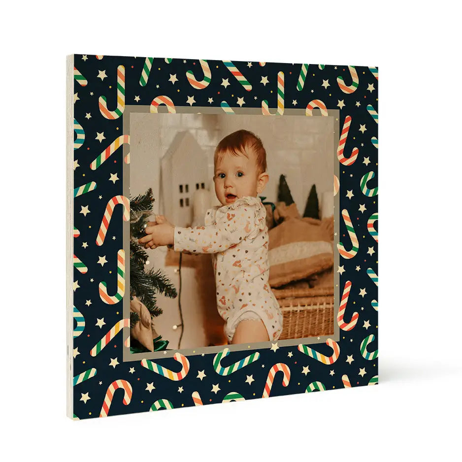 Baby in holiday pajamas reaching for a Christmas tree by Birch Pattern Wood Print