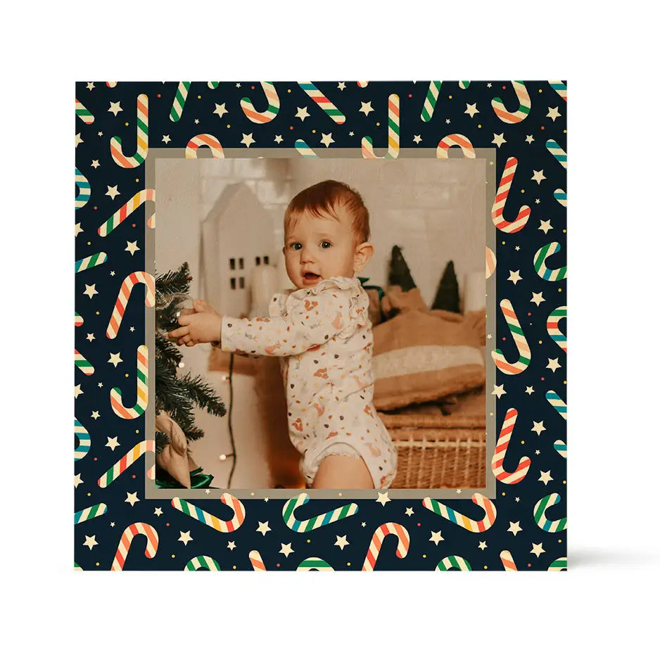 Young child in a white onesie reaching for a Christmas tree with Birch Pattern Wood decoration