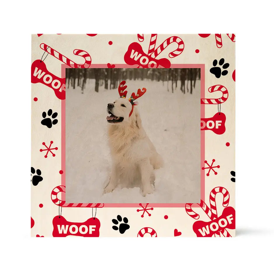 Framed photo of a white dog in reindeer antlers on snowy birch pattern wood background