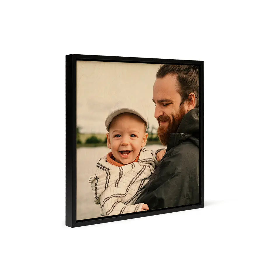 A man holding a baby in his arms framed in a Birch Square Black Frame