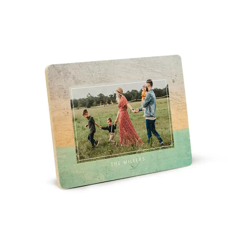 Distressed mint green and beige photo frame showcasing a family picture in a field.