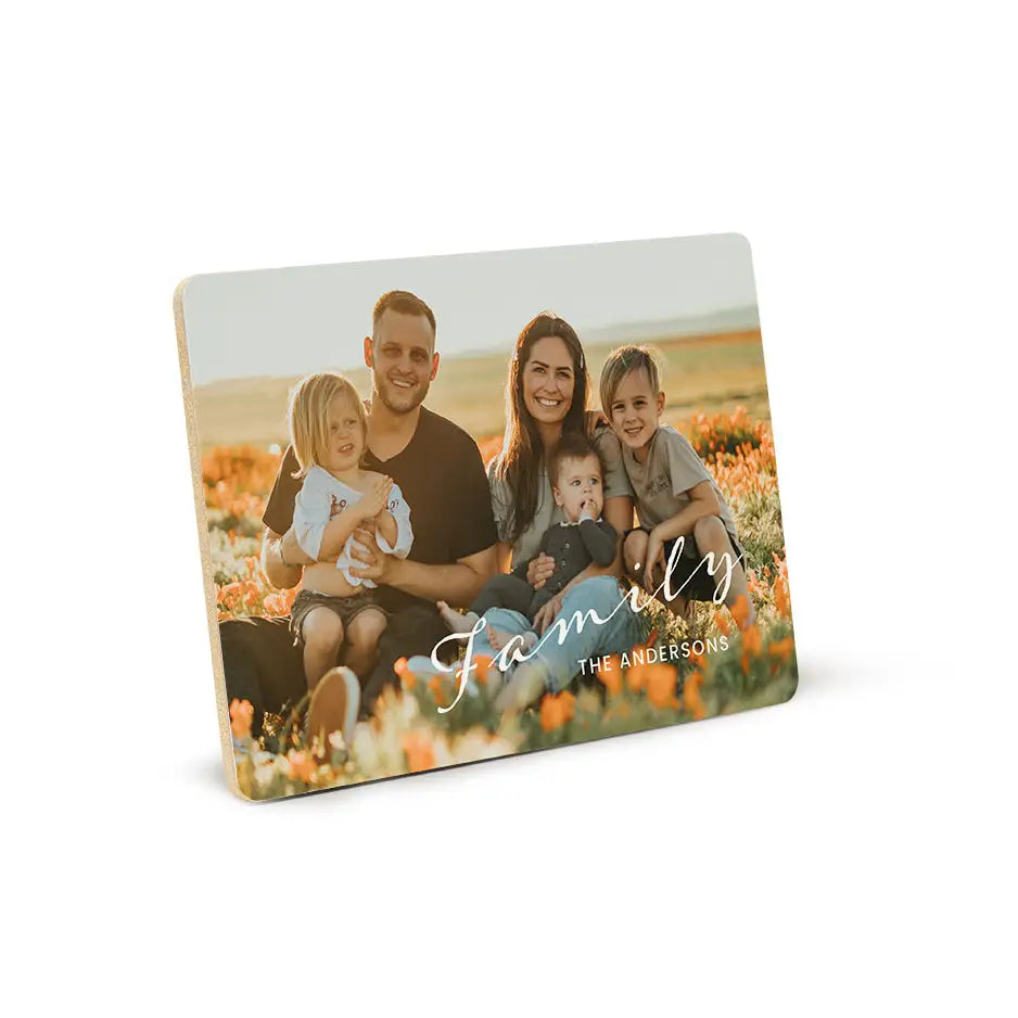 Family posing with a Family Script Wood Plaque featuring the word love