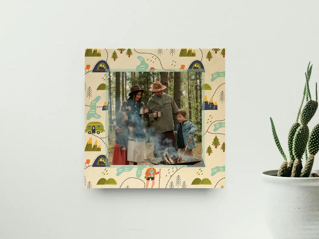 A framed photograph of a family camping, featuring a decorative border with outdoor-themed illustrations.
