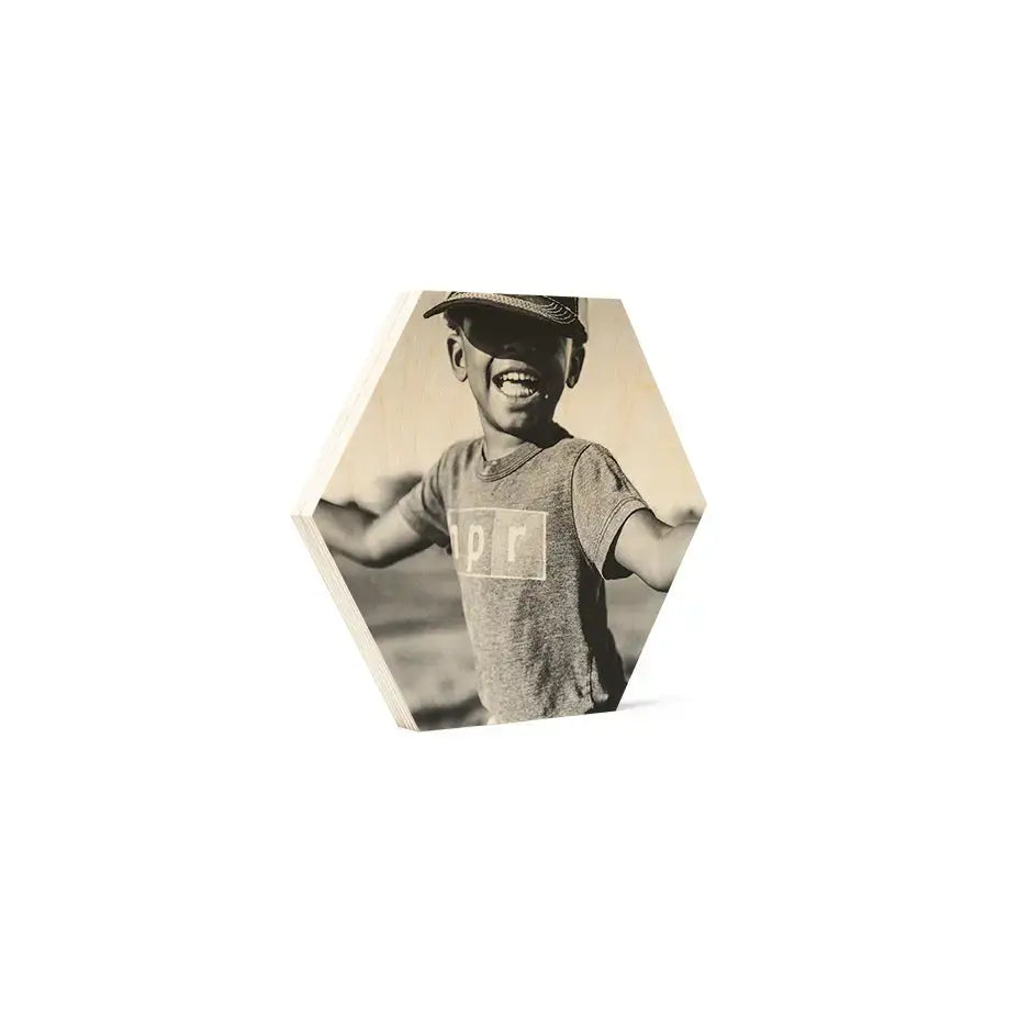 Smiling child in vintage matte t-shirt captured in hexagonal birch wood print.