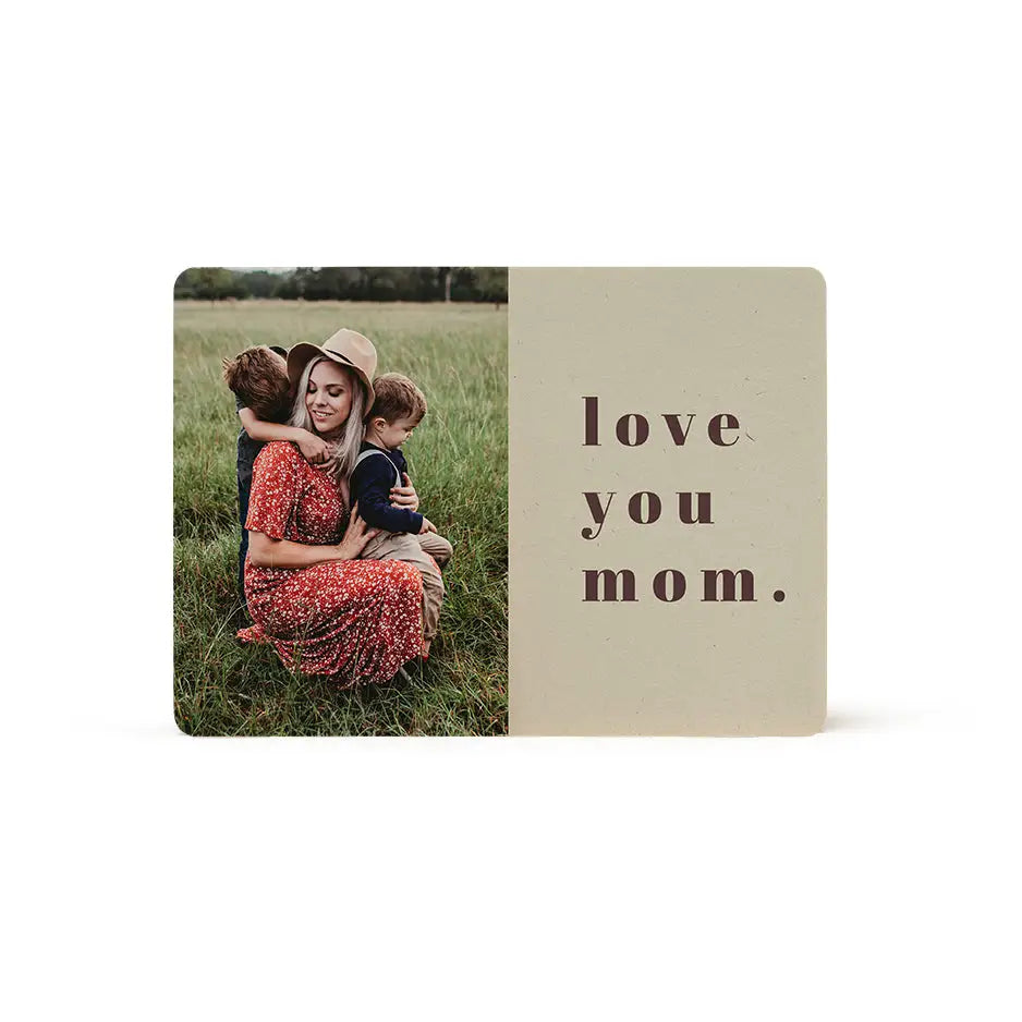 Couple hugging in grass with Love You Mom Wood Plaque for heartfelt gifting