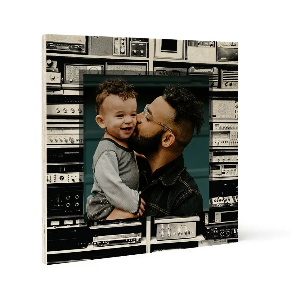 Framed photo locket wood print of a man kissing a child near vintage analog radio