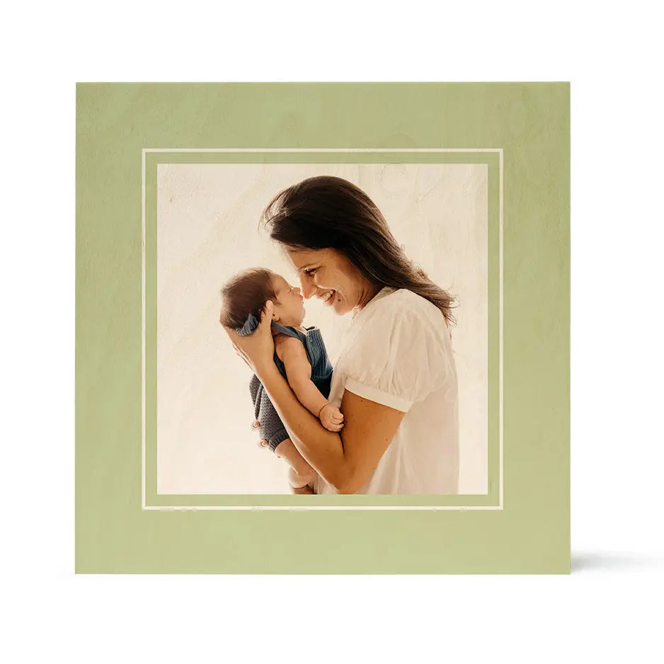 Framed photograph of a woman holding a baby with a matte cactus green border