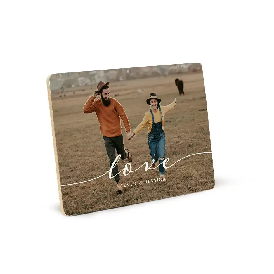 Couple dancing in a field on a custom wood plaque with love text overlay.