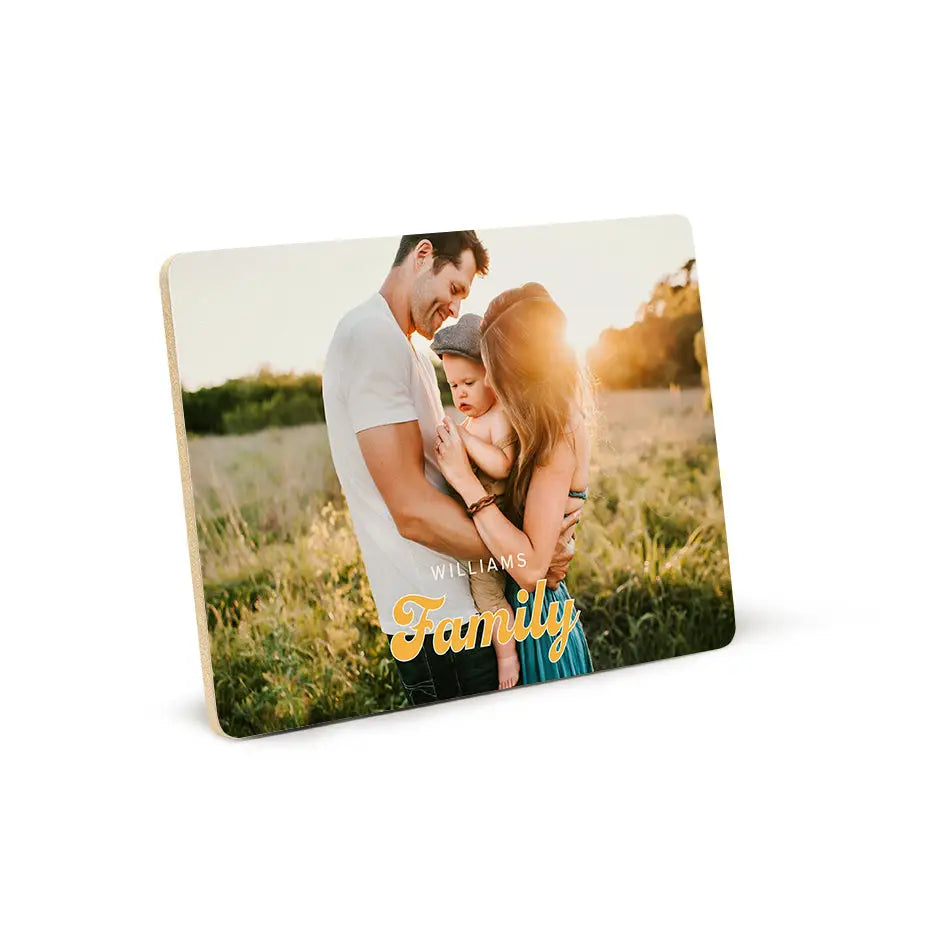 Couple kissing in a field displayed on a Retro Family Wood Plaque