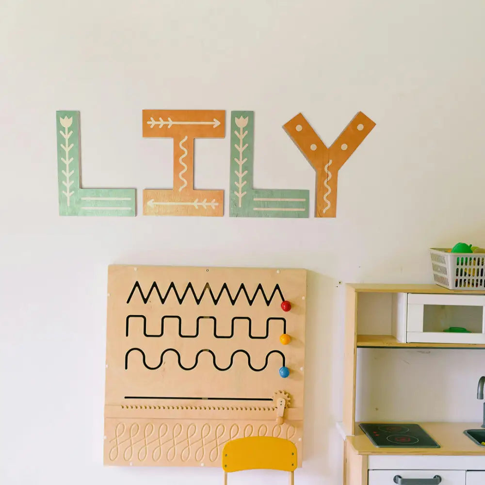 Decorative wall letters spelling ’LILY’ in colorful, patterned designs.