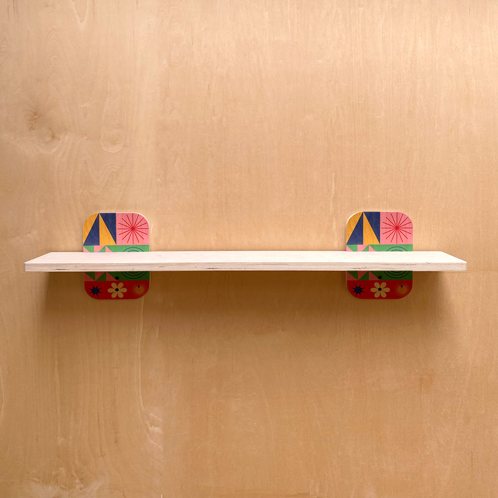 White shelf with colorful exclusive geometric supports on sturdy wall shelves for natural warmth
