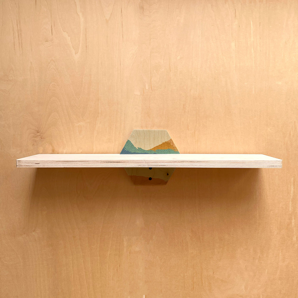 Wooden wall shelf with painted mountain design, a sturdy wall shelf for your space