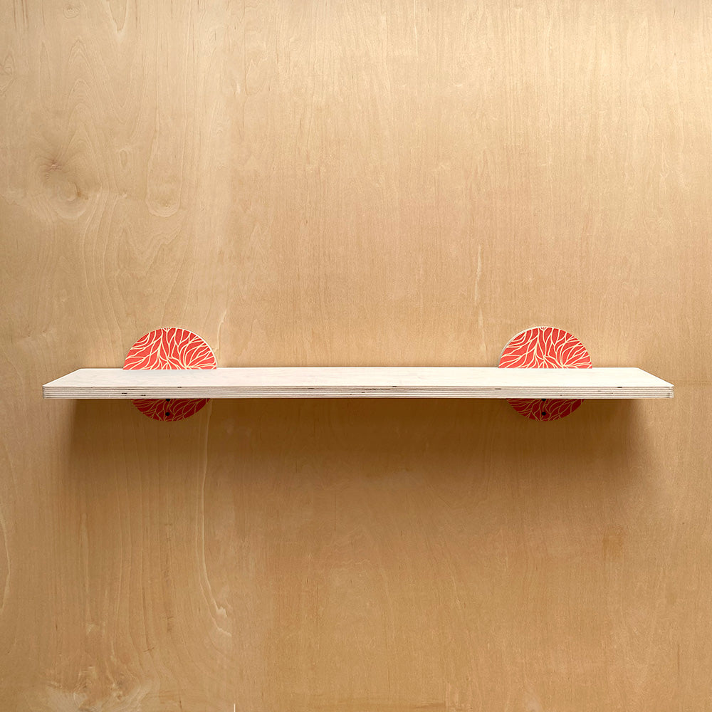White sturdy wall shelf with patterned supports for a nature inspired decor look
