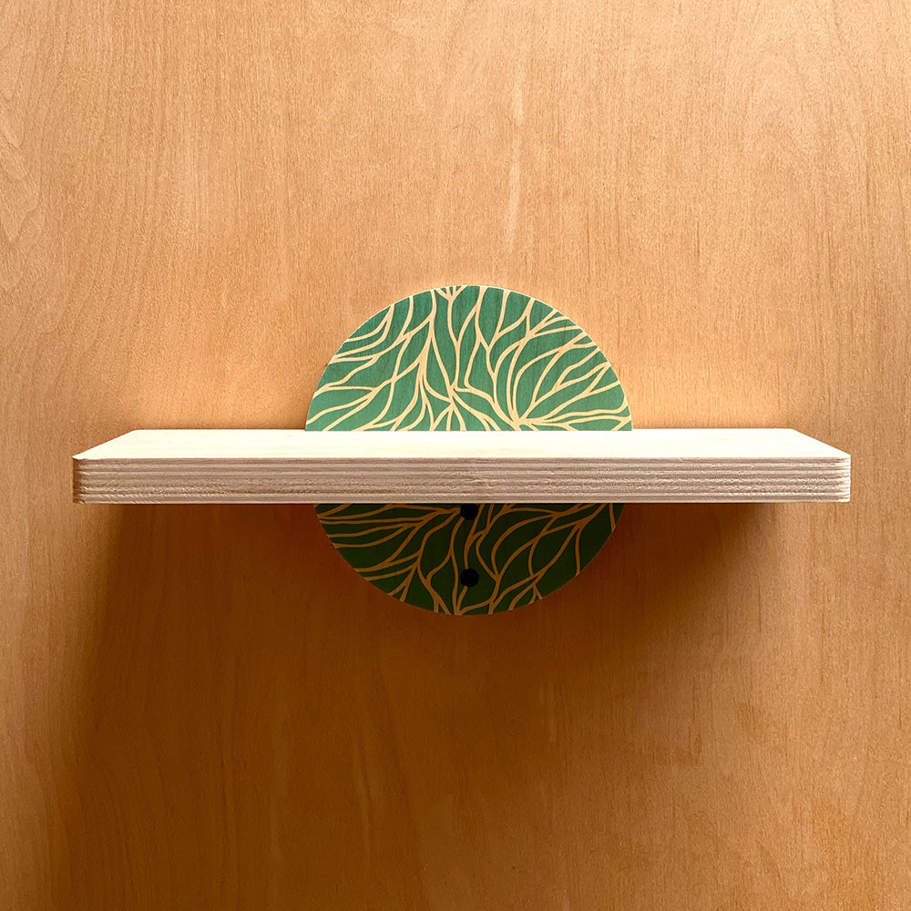 Wooden wall shelf with green leaf design and circular brackets for a sturdy wall display