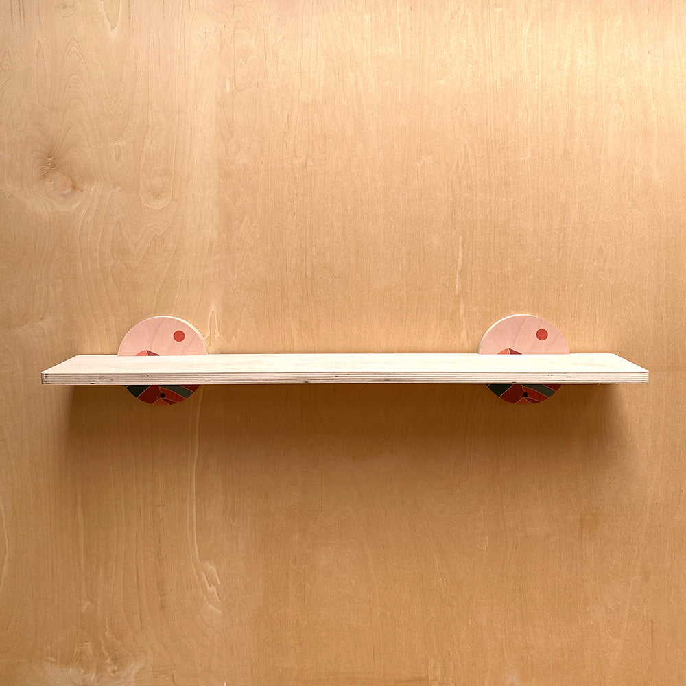 White sturdy wall shelf with pink floral supports, perfect for stylish storage