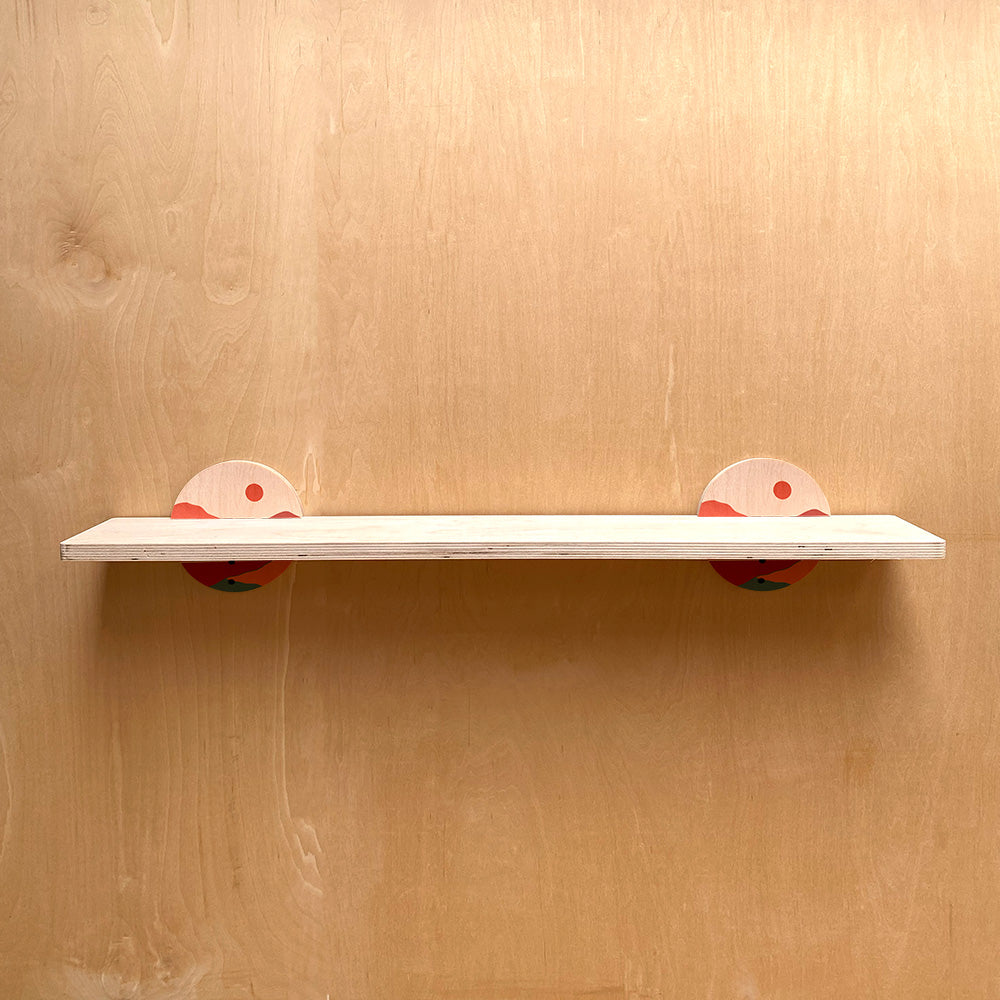 White sturdy wall shelf with colorful circular supports blending functionality and art