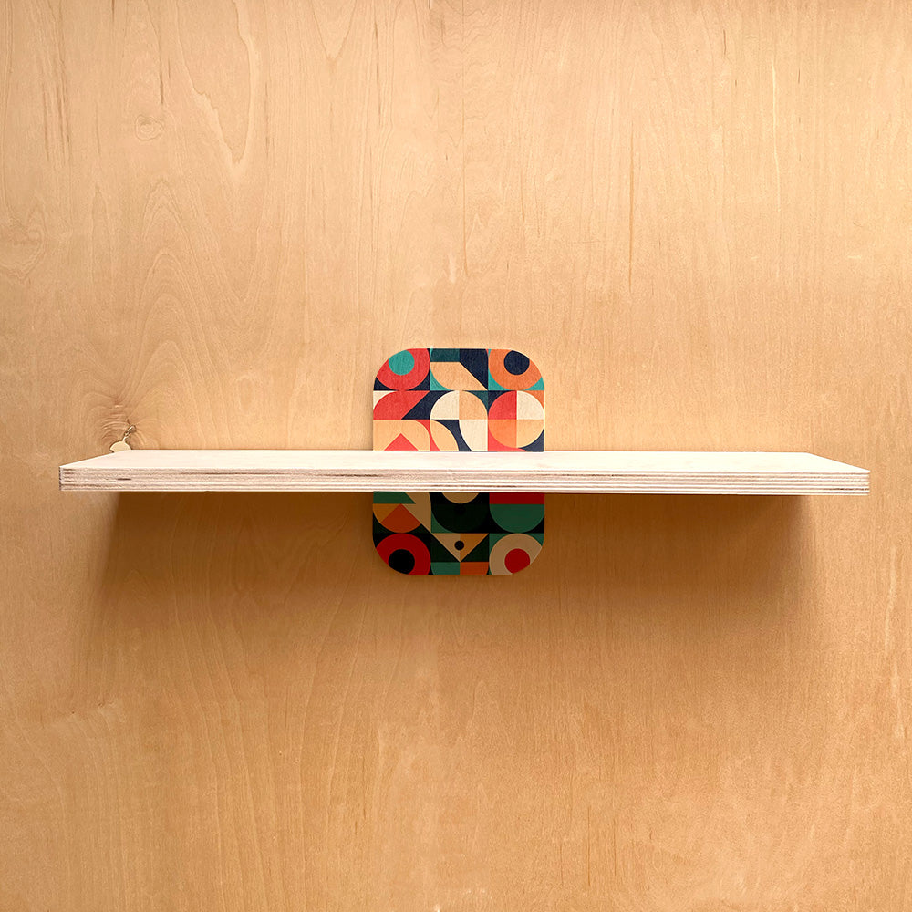 White sturdy wall shelf with geometric patterned support for stylish storage