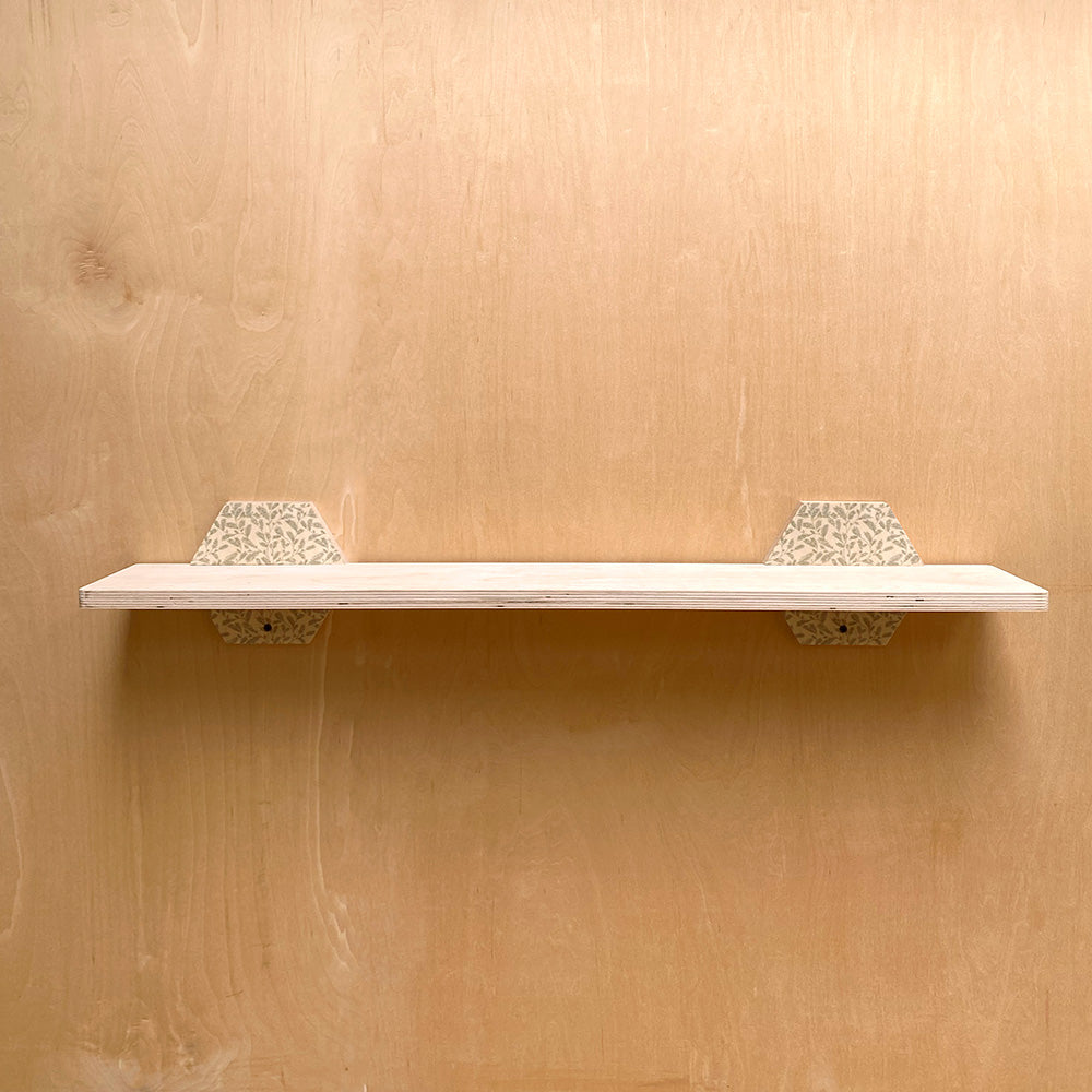 White sturdy wall shelf with patterned brackets for natural charm and robust support