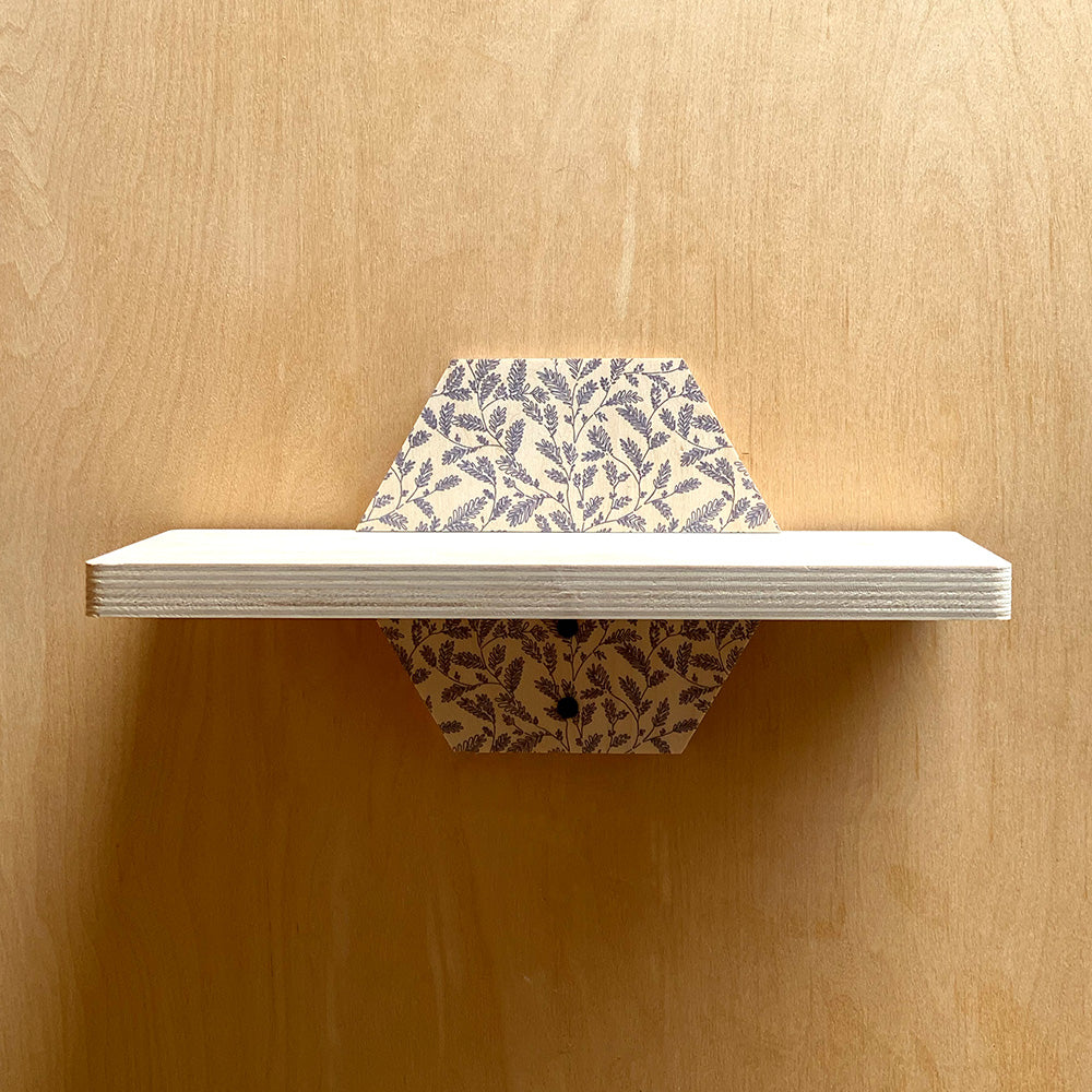White sturdy wall shelf with patterned supports showcasing natural charm